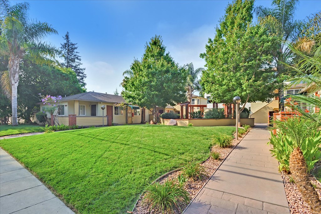 a house with a yard and a sidewalk in front of it