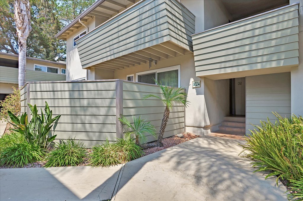 a side view of a house with a driveway and a porch