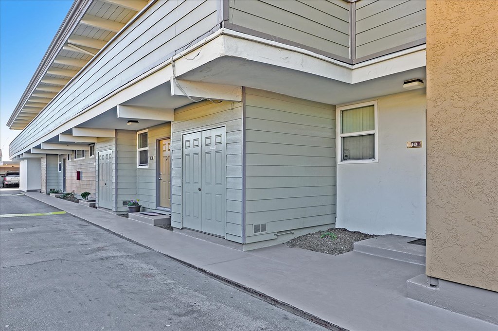 the front entrance of an apartment building with a sidewalk