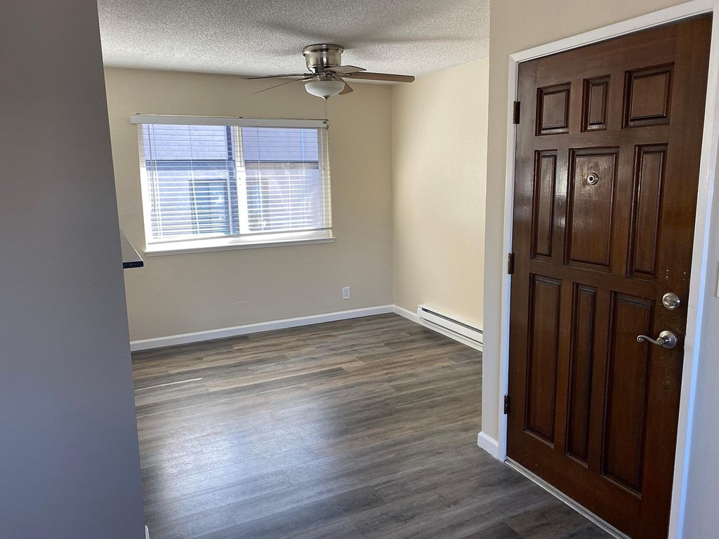A room with a ceiling fan and a door.