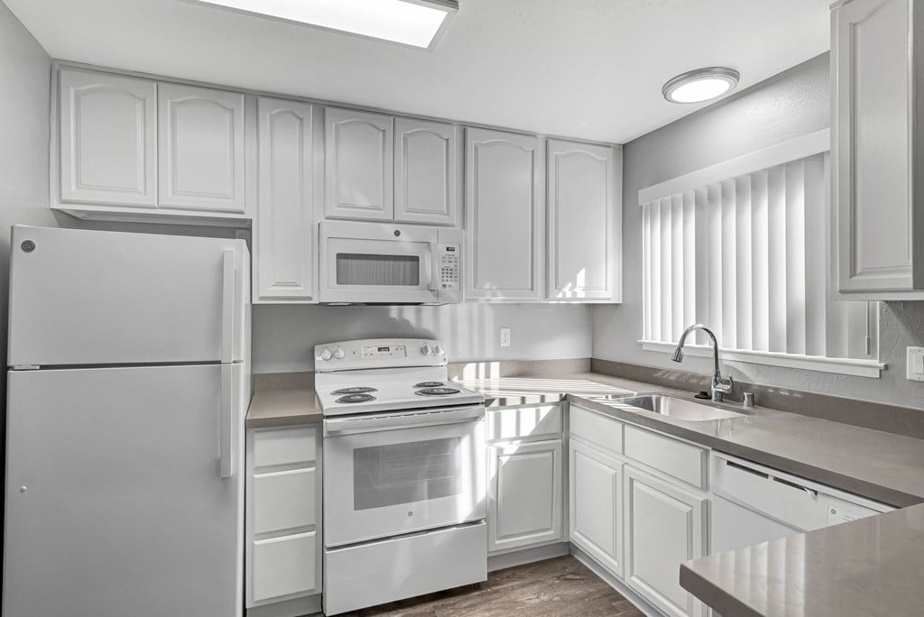 A kitchen with white appliances and cabinets.