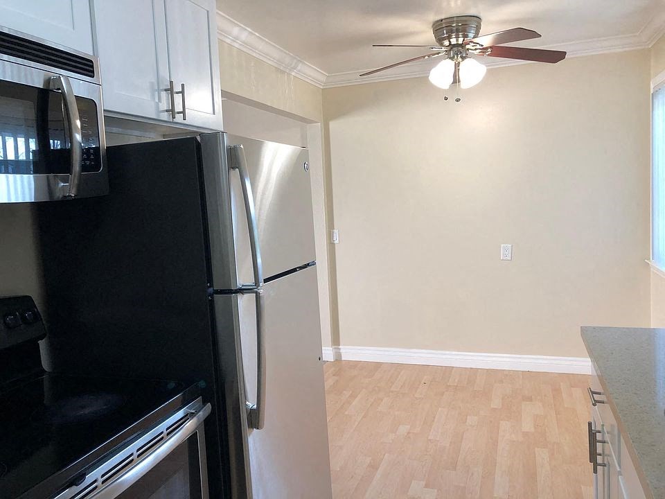 a kitchen with a refrigerator and a ceiling fan