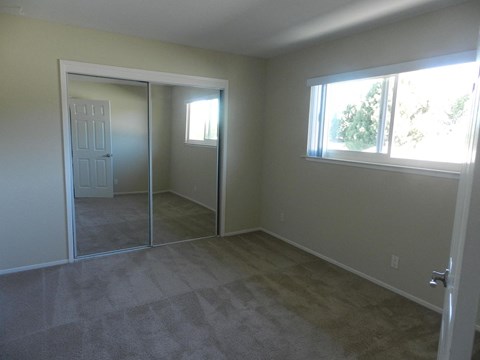 A room with a carpeted floor and a sliding glass door.