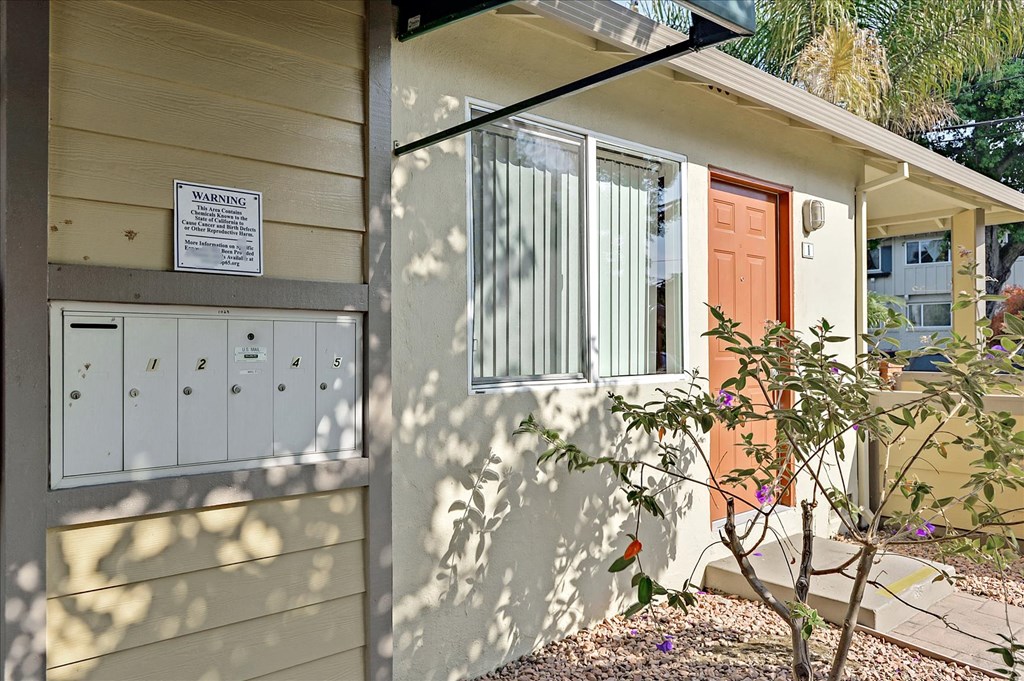 a side view of a house with a door and a mailbox