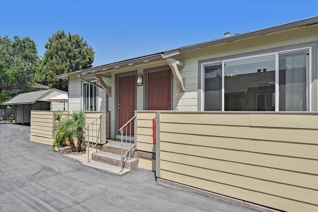 A beige mobile home with a brown door and a small porch.