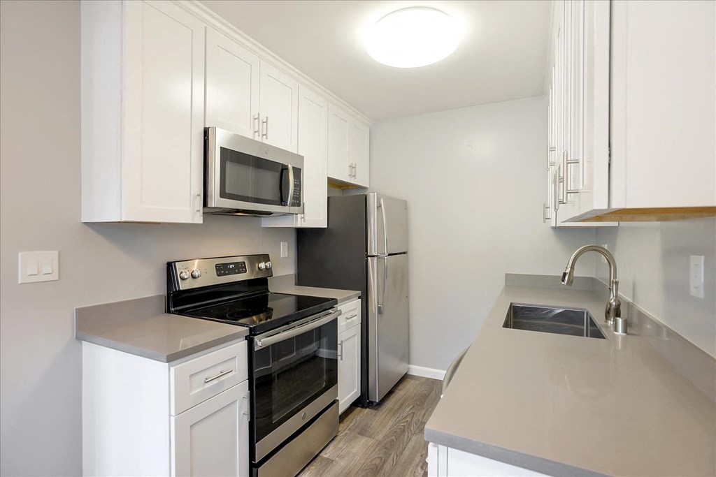 A kitchen with white cabinets and stainless steel appliances.