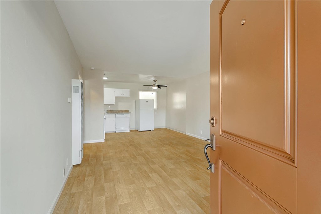 an open living room and kitchen with a wooden door