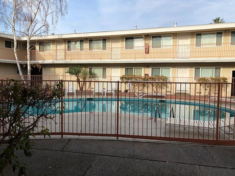 a swimming pool is behind a wrought iron fence