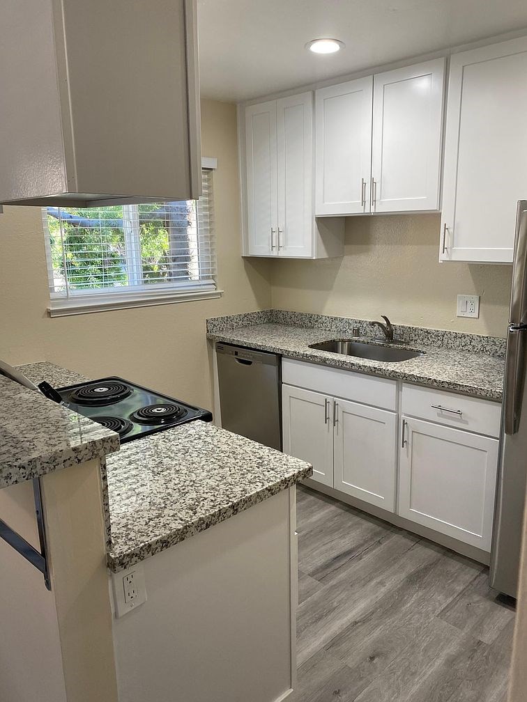A kitchen with granite countertops and white cabinets.