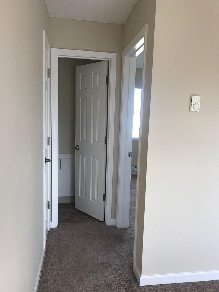 a room with a white door and a hallway with a door open