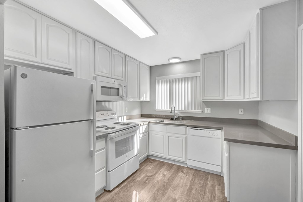 A modern kitchen with white appliances and cabinets.