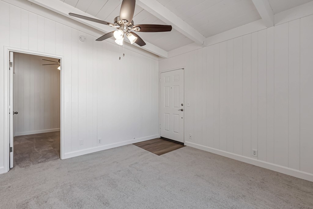 A room with a ceiling fan and two doors.