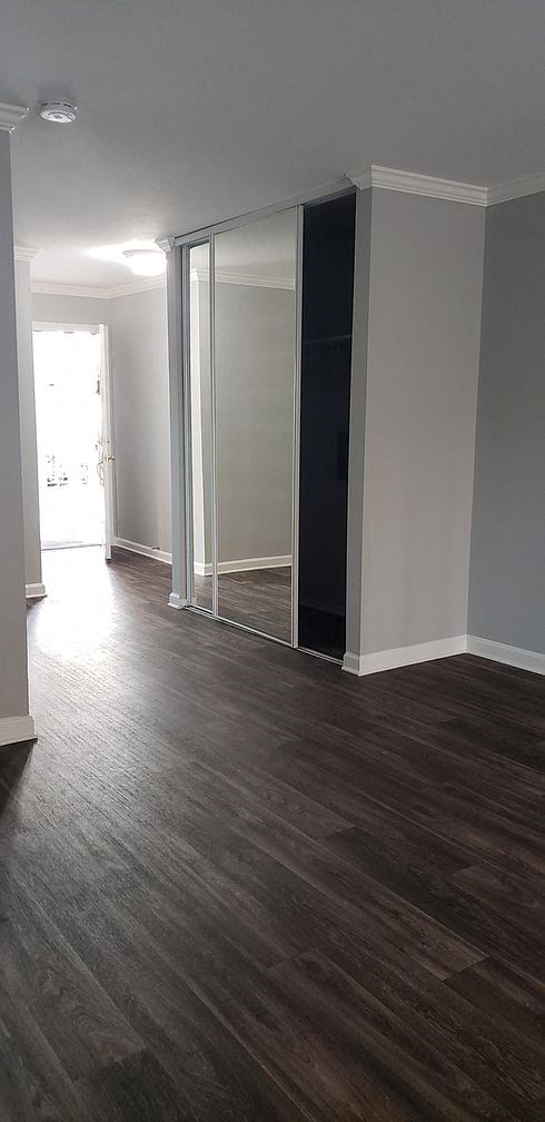 A room with a sliding door and wood flooring.