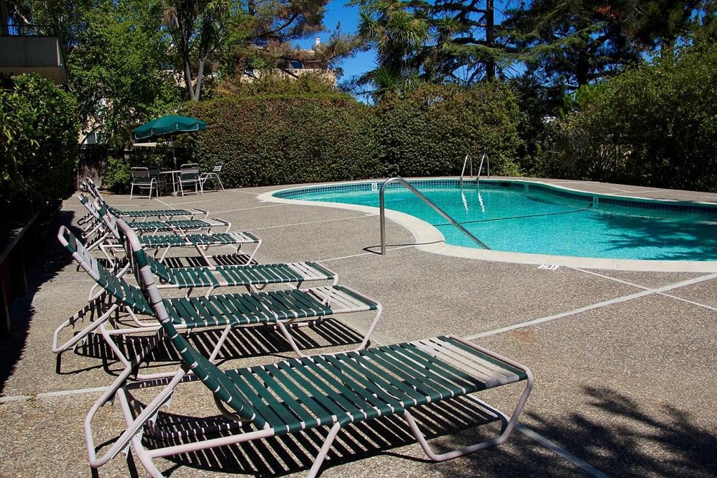 A pool with chairs around it.
