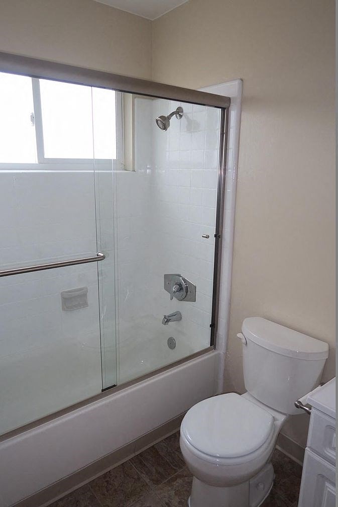 a white bathroom with a shower and a toilet
