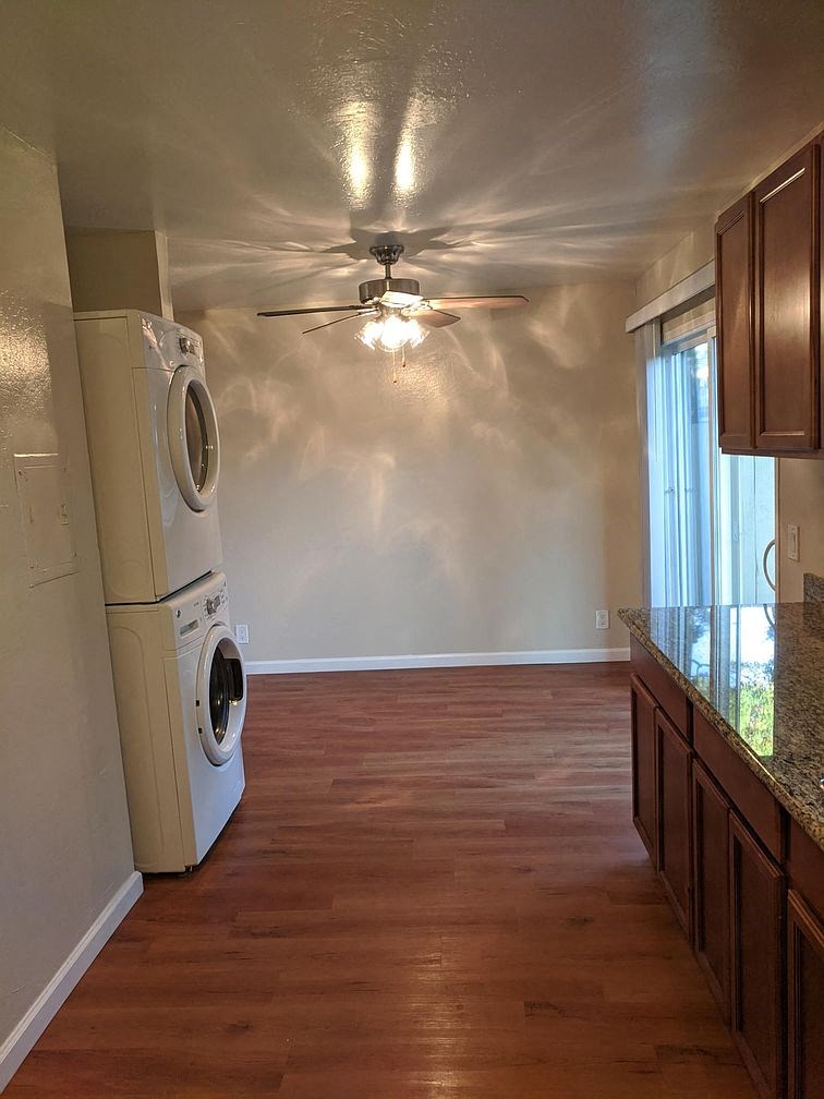a kitchen with a washing machine and a ceiling fan