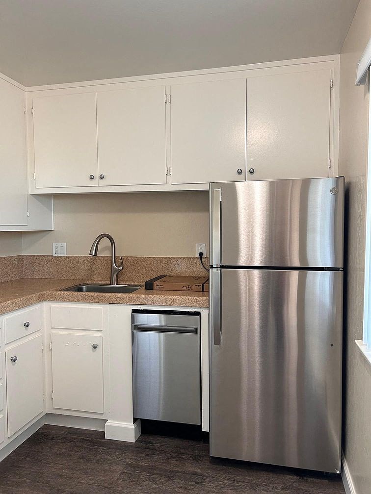 a kitchen with a stainless steel refrigerator and a sink