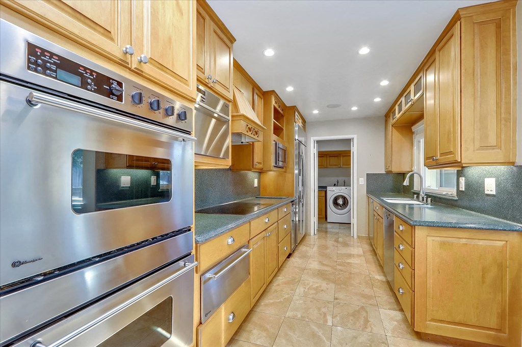 a kitchen with wooden cabinets and stainless steel appliances