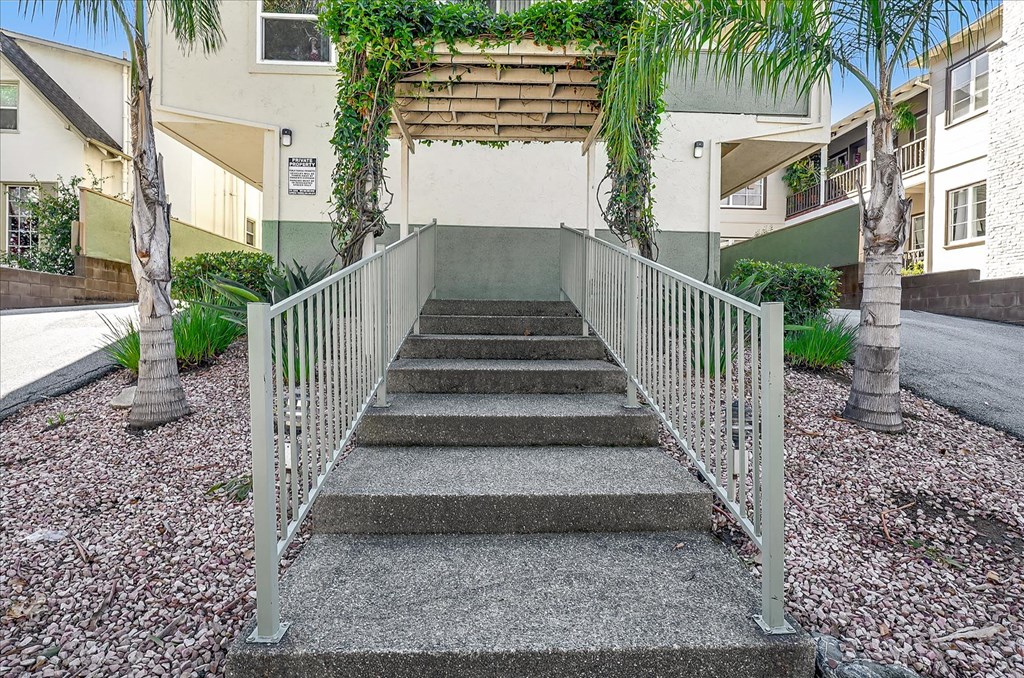 a metal bridge with stairs in front of an apartment building