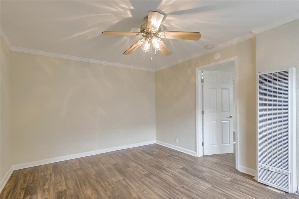a living room with a ceiling fan and a door