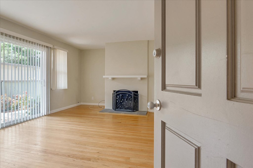 an empty living room with a fireplace and a window