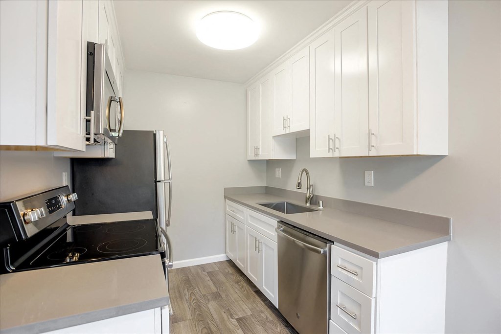 A kitchen with white cabinets and stainless steel appliances.