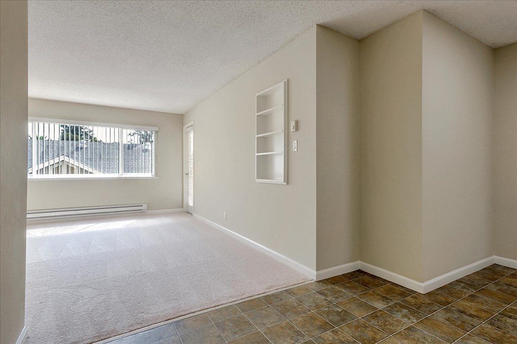 an empty room with a window and tile floor