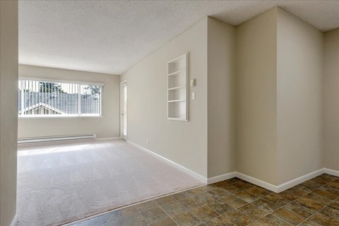 an empty room with a window and tile floor