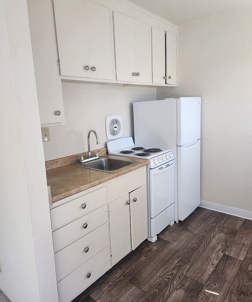 A kitchen with white appliances and cabinets.