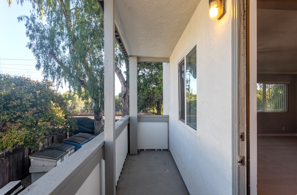 the front porch of a home with a large window and a bench