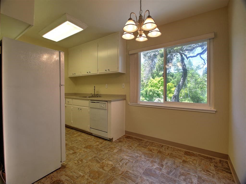 a kitchen with a large window and a white refrigerator