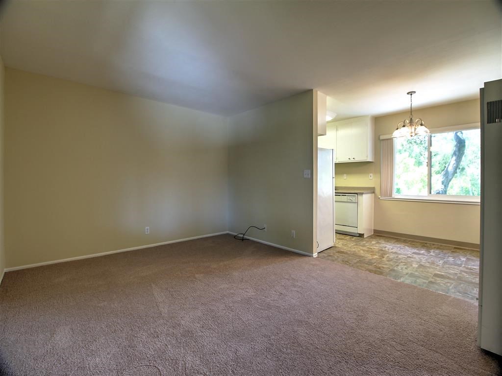 an empty living room with a kitchen in it