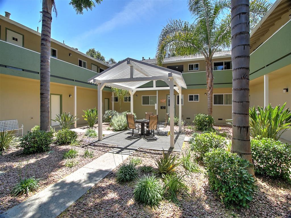 a patio with a table and chairs in a courtyard