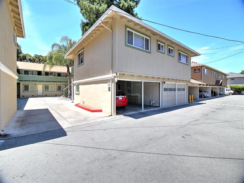 a parking lot in front of a building with a car in the garage