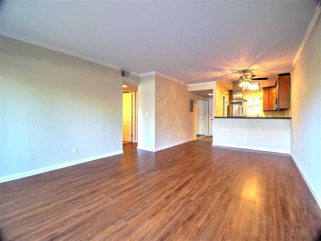 an empty living room with a ceiling fan