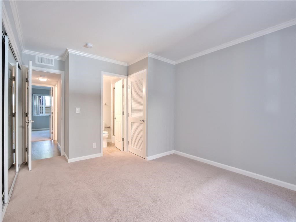 an empty living room with a closet and a bathroom