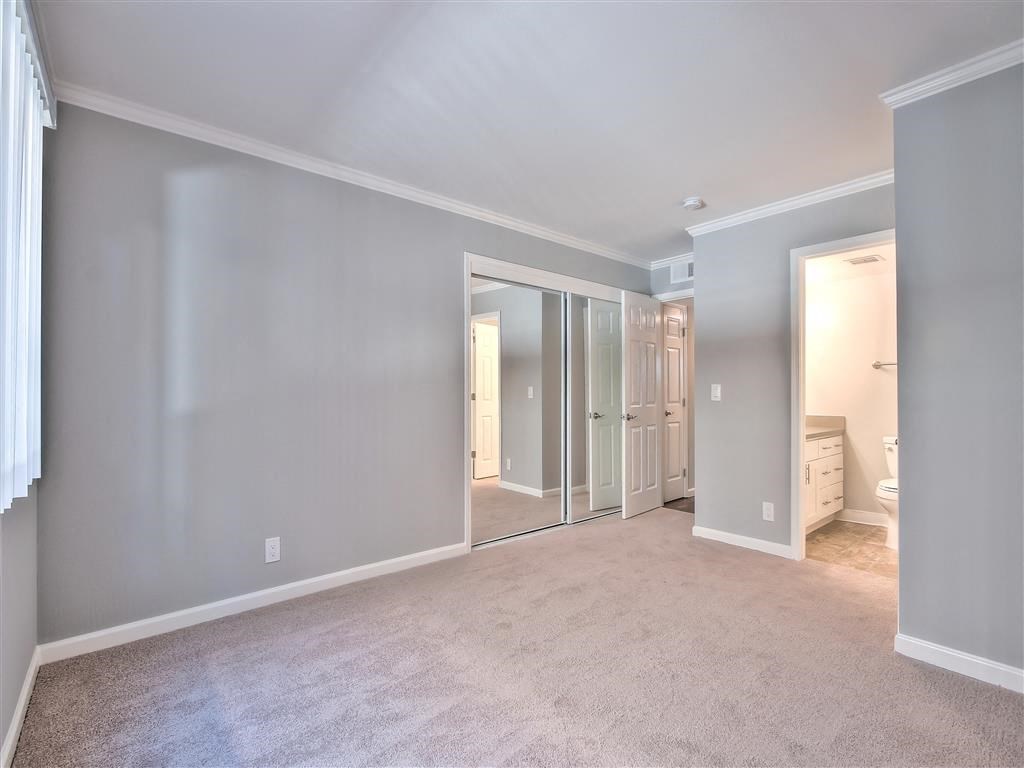 a bedroom with a closet and a mirror in a house