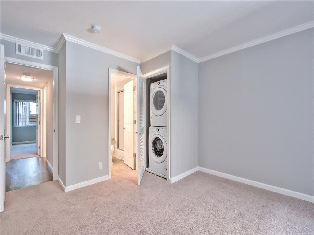 a living room with a washer and dryer in a closet