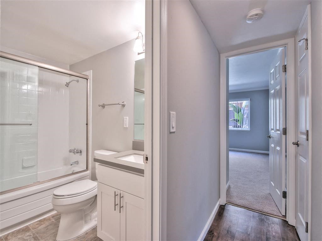 a white bathroom with a toilet and a shower