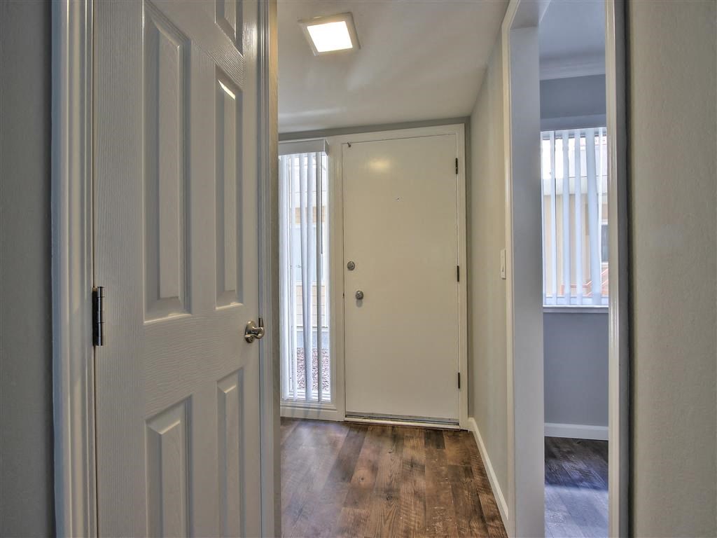 a hallway with a white door and a door to a bedroom