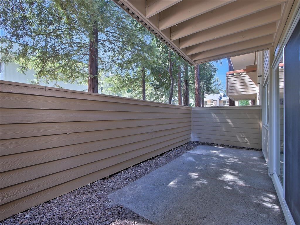 a covered porch with a view of trees and a house