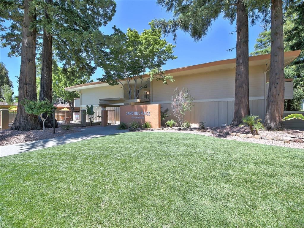 a house with a yard and trees in front of it
