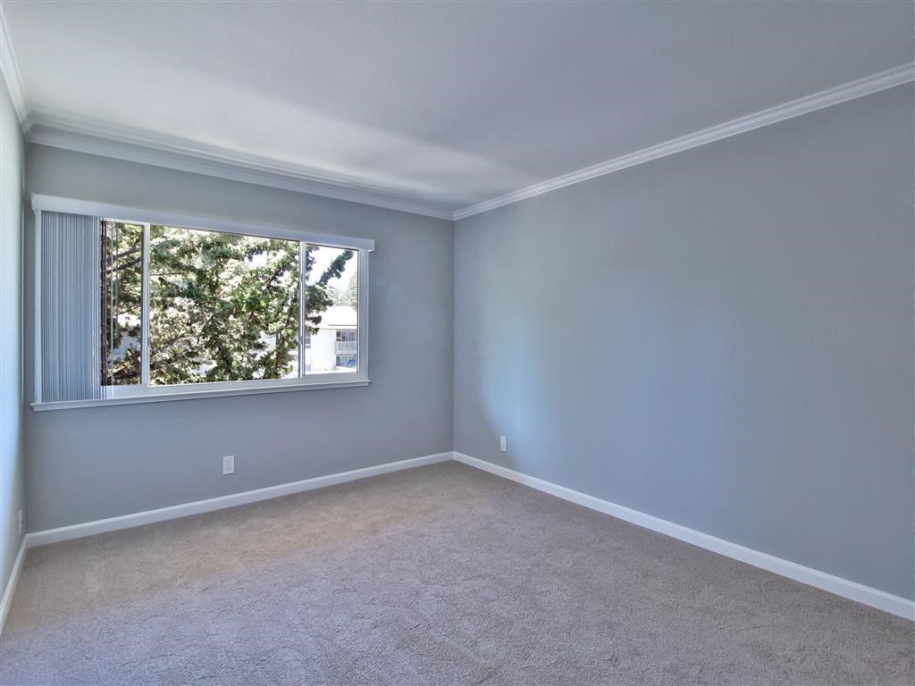 an empty room with a window and carpet
