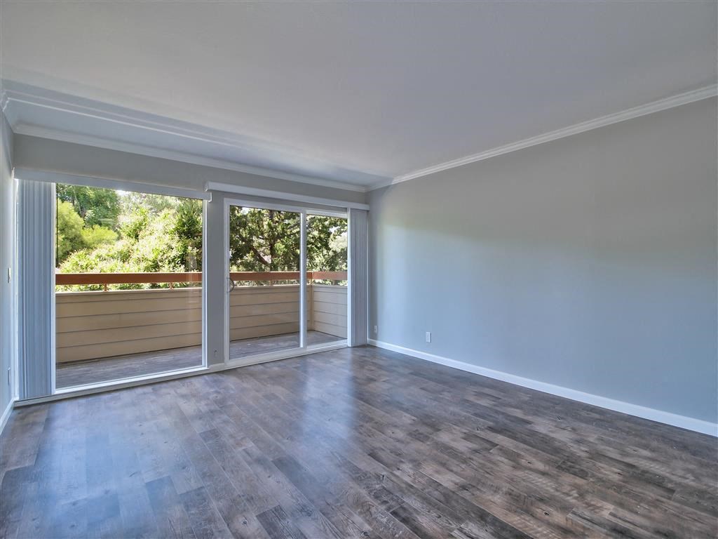 an empty living room with sliding glass doors to a balcony