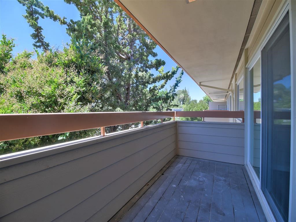 a balcony with a view of trees and a blue sky