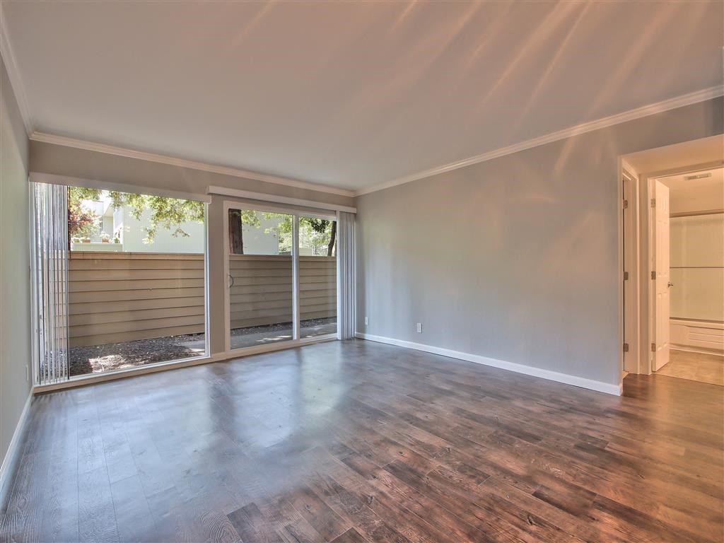 an empty living room with sliding glass doors to a patio