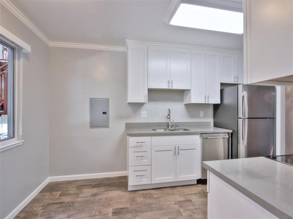 a kitchen with white cabinets and a stainless steel refrigerator