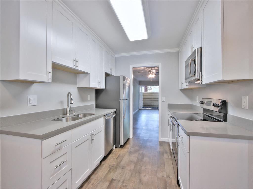 a kitchen with white cabinets and stainless steel appliances