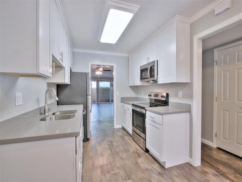 a kitchen with white cabinets and stainless steel appliances