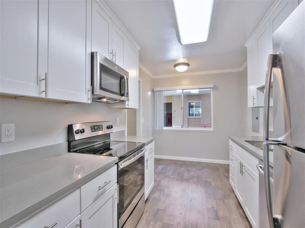 a kitchen with white cabinets and stainless steel appliances